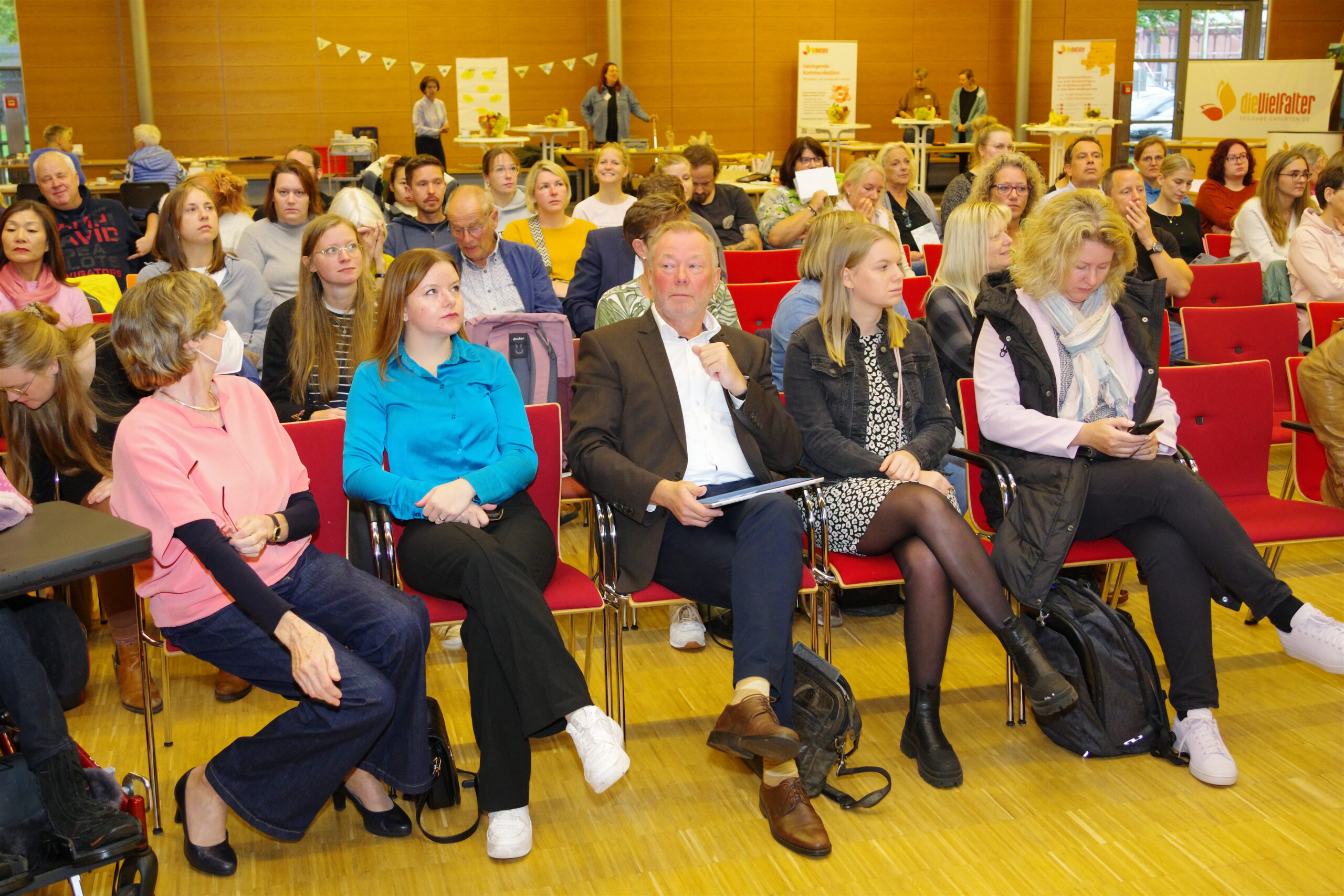 Zuhörer bei einem Fachtag für unterstützte Kommunikation im Gesundheitswesen sitzen im Vortrag.